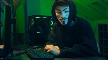 Lviv, Ukraine - June 03, 2024. Man hacker anonymous attack bank criminal typing computer keyboard network cyberspace virus danger technology unrecognizable programmer software fraud system stealing pc photo