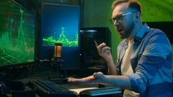 Angry Caucasian man male freelancer business crypto analyst talking mobile phone negotiations guy looking computer screen annoyed trader argue quarrel stress neon at home scam problem error night work photo