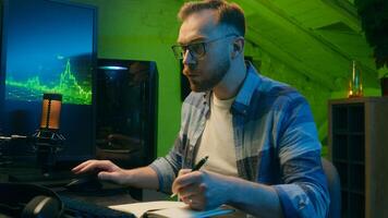 Focused serious Caucasian man freelancer male modern guy working writing results programmer crypto analyst typing keyboard computer pc concentration e-commerce home neon night trading stock deadline photo