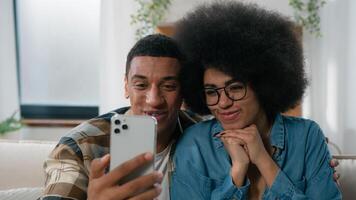africano americano contento Pareja familia riendo hablando agradable conversacion virtual llamada móvil teléfono conferencia aplicación distante hablar saludo marido y esposa a hogar con teléfono inteligente cámara web hablar foto