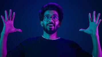 Male portrait neon ultraviolet background Arabian man Indian guy coder hacker showing head mind explosion gesture boom brainstorm idea mental shock information think computer technology sci-fi future photo