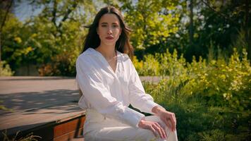 Thoughtful serious elegant dreaming caucasian woman businesswoman model posing in city park worried pensive frustrated girl female student business lady sitting outdoors looking away turning to camera photo