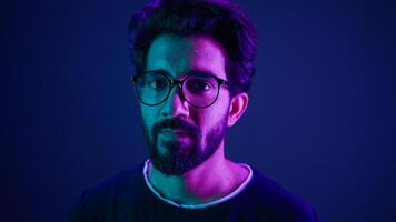 Close up portrait neon ultraviolet background Indian man guy developer coder smart hacker clever coding computer engineer showing gesture think about it thinking hard brain mental ponder IQ remember photo