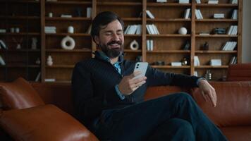 Relaxed laughing Caucasian mature smiling male businessman client user man entrepreneur laugh using mobile phone browsing smartphone scroll social media app chat business working on break office room photo