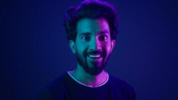 Portrait Indian man standing in profile side view turn to camera smiling toothy happy guy developer coding smile computer internet technology hacker Arabian male neon ultraviolet high-tech cyberspace photo