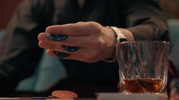 Skilled unknown drunk Caucasian male man guy player gambler smoking cigar holding hands tokens chips playing poker gaming gamble drinking alcohol whiskey home room. Addiction gambling health problems photo