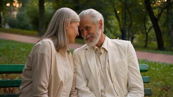 Portrait cute romantic happy senior family smiling Caucasian elderly couple man woman cuddling talk discuss looking at camera resting relaxing together outside city park healthcare retirement marriage photo