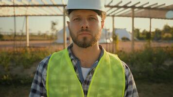 Close up portrait thoughtful serious Caucasian male engineer builder man guy controller helmet uniform hold checking tablet notebook looking camera outdoors countryside. Ecology industrial engineering photo