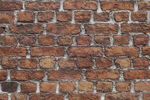 Closeup and detail of an old, weathered wall with reclaimed bricks in irregular patterns photo