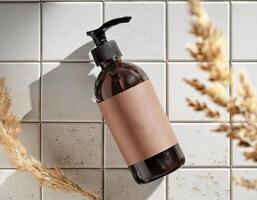 Brown bottle of hand soap on a tiled wall photo