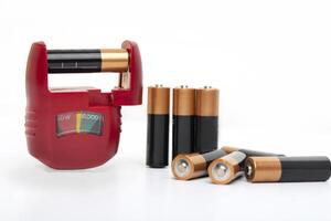 Battery tester, battery level indicator with assortment of dry cells for testing on a white background photo