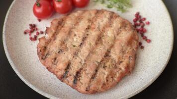 Juicy grilled beef or pork steak with salt, spices and herbs on a dark concrete background video