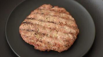 Juicy grilled beef or pork steak with salt, spices and herbs on a dark concrete background video