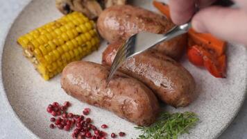 Chicken or pork sausages with salt, spices and herbs baked on the grill on a dark concrete background video