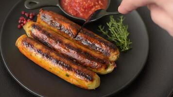Chicken or pork sausages with salt, spices and herbs on a dark concrete background video
