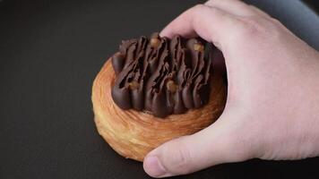 Sweet dessert danish covered with chocolate cream, with cream filling on a dark concrete background video