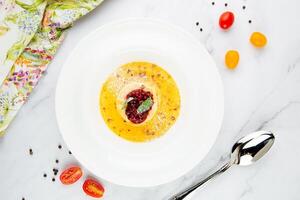Ginger pumpkin soup with dumplings and berries. White background top view photo