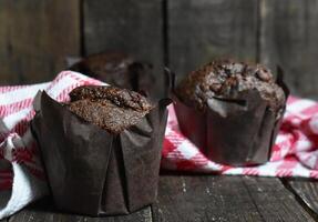 Chocolate muffins on wood background photo