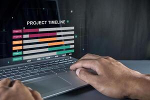 Man working on laptop to check the project timeline, milestones and planning progress on virtual screen photo