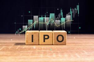 Wooden blocks with the word IPO and virtual stock graph. Initial Public Offering or stock launch concept. photo
