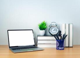 Laptop with blank screen on white table and office supplies on wooden background. Space for copying your text. Workspace and copy space. Desk with office supplies. photo