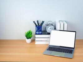 Space for copying your text. Laptop with blank screen on white table and office supplies on wooden background. Workspace and copy space. Desk with office supplies. photo
