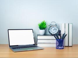 Space for copying your text. Laptop with blank screen on white table and office supplies on wooden background. Workspace and copy space. Desk with office supplies. photo