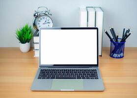 Space for copying your text. Laptop with blank screen on white table and office supplies on wooden background. Workspace and copy space. Desk with office supplies. photo