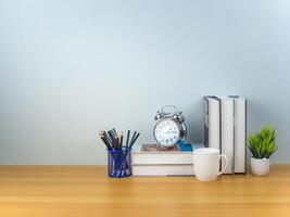 Workspace mock up white table top with Coffee cup, Pencils, Book, Alarm clock and green houseplant,Copy space desk with copy space for products display montage, Minimalist workplace with supplies. photo