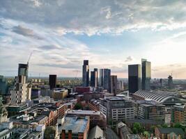 Aerial View of Greater Manchester City Centre and Tall Buildings During Golden Hour of Sunset. England UK. High Angle Footage Was Captured with Drone's Camera During Windy day of May 5th, 2024 photo