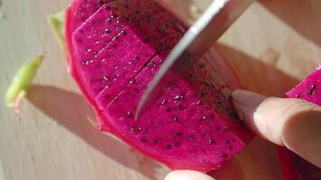A vibrant and colorful Dragon Fruit slice beautifully displayed on a rustic wooden surface video