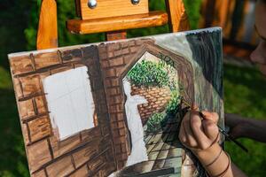 Close-up of someone skillfully painting on a canvas. The artwork looks like it depicts a rustic scene, possibly featuring elements like bricks or wood, giving it a cozy, homely feel. photo