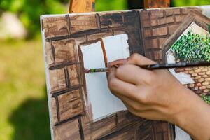Close-up of someone skillfully painting on a canvas. The artwork looks like it depicts a rustic scene, possibly featuring elements like bricks or wood, giving it a cozy, homely feel. photo