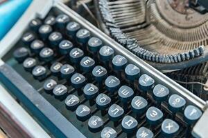 Vintage typewriter with a close-up on the keyboard. The keys are worn and dusty, suggesting years of use. photo