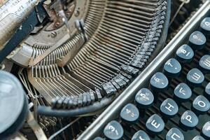 Vintage typewriter with a close-up on the keyboard. The keys are worn and dusty, suggesting years of use. photo