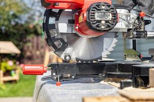 Miter saw, construction tool ,carpentry home renovation backgrounds, copy space image. Miter saw with a protective screen. Safe equipment for the furniture and construction industry. Close-up. photo
