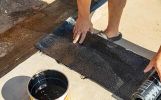 Construction techniques for waterproofing basement and foundations. Insulation material on the basement concrete wall. Waterproofing house foundation with spray on tar and roll waterproofing photo