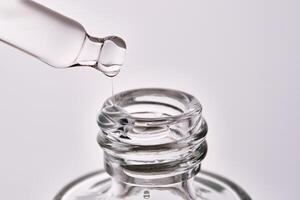 Close-up of a cosmetic bottle with a pipette showing the texture of the serum. photo