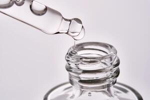 Close-up of a cosmetic bottle with a pipette showing the texture of the serum. photo