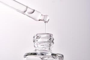Close-up of a cosmetic bottle with a pipette showing the texture of the serum. photo