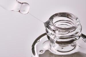 Close-up of a cosmetic bottle with a pipette showing the texture of the serum. photo