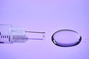 Injection syringe on a medical tray in bright violet color. photo