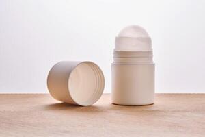 Roll-on deodorant on a background with beige grooves. photo