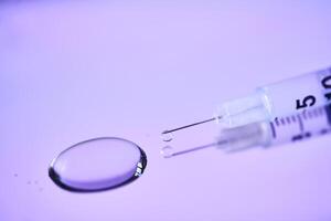 Injection syringe on a medical tray in bright violet color. photo