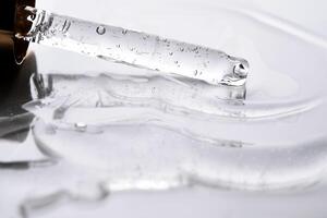 Dropper pipette with delicious serum with bubbles on the gel texture. photo