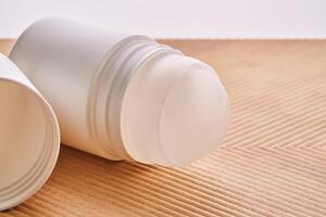 Roll-on deodorant on a background with beige grooves. photo