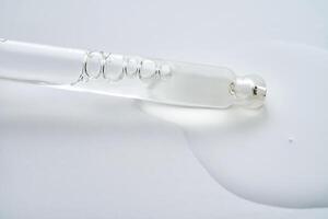 Dropper pipette with delicious serum with drop close-up. photo