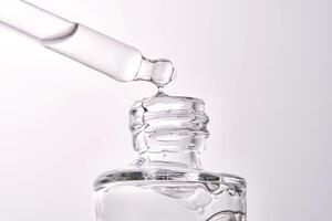 Close-up of a cosmetic bottle with a pipette showing the texture of the serum. photo