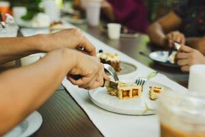 Woman hands cutting waffles with fork and knife on plate in cafe. photo