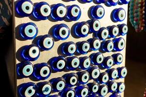 Unique collection of blue evil eye charms displayed in a market setting during daylight photo
